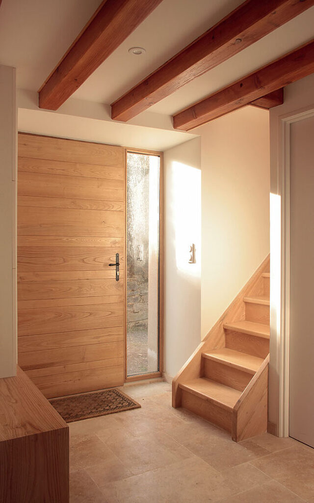 Chaleureuse entrée du gîte écologique rénové à Lacaune. Porte réalisée en châtaignier
par le menuisier du village d’à côté. Escalier en frêne.