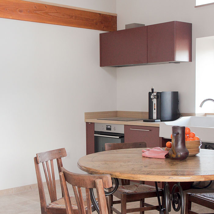 Table et chaises de famille dans cette cuisine du gîte écologique rénové à Lacaune