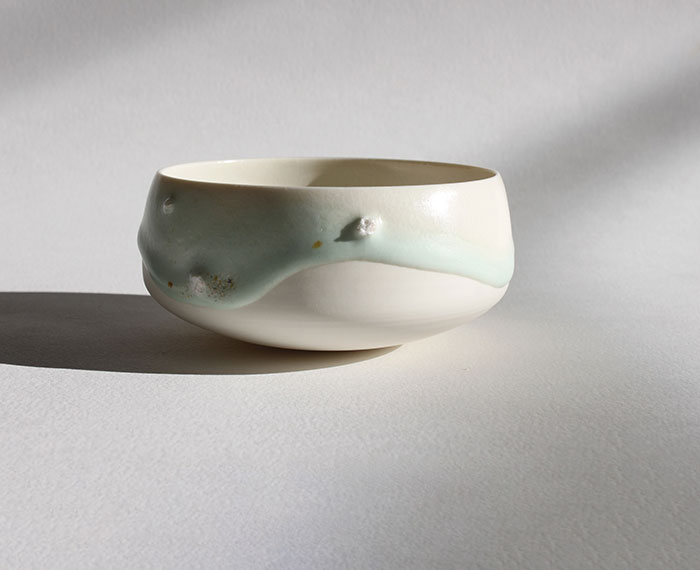 Céramique contemporaine avec un bol en porcelaine, émaux, roches et sables.