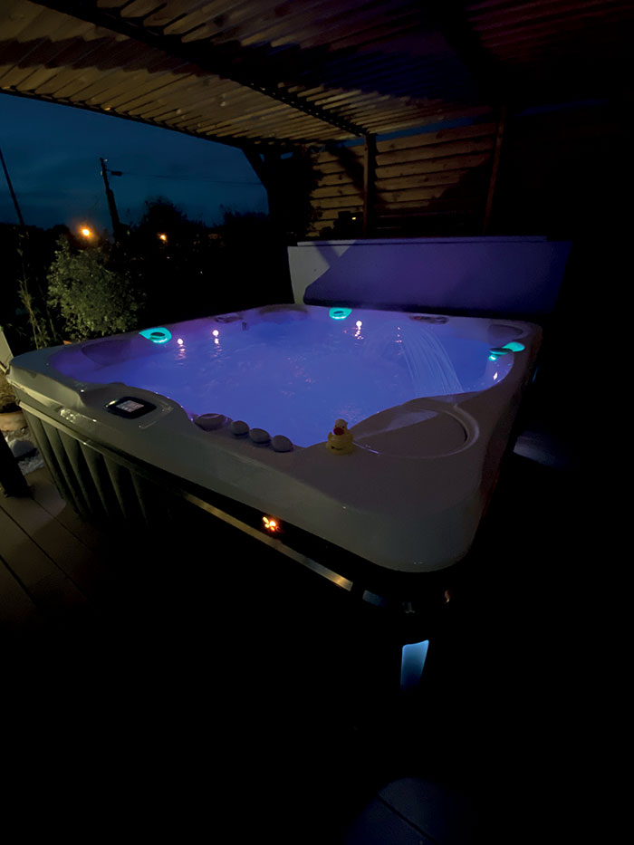 Un spa pour une cure de bien-être avec en visuel un spa de la marque Caldera Spas de nuit avec LED intégrées